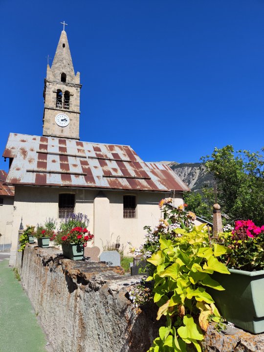 Eglise de montagne typique du Briançonnais sur chemin de trail, au printemps